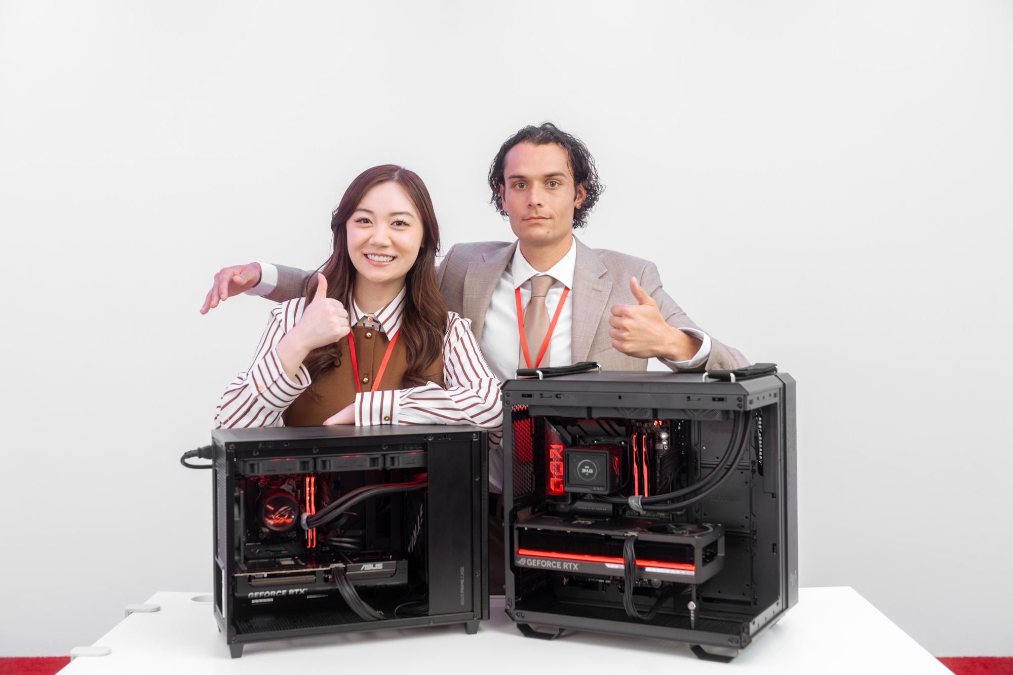 Một người đàn ông và một người phụ nữ đứng đằng sau hai bản dựng PC đã hoàn thành, cả hai đều đưa ra một ngón tay cái, với người đàn ông mở rộng cánh tay của mình quanh vai người phụ nữ mà không thực sự chạm vào cô ấy